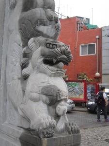 A carved stone lion guards the gateway into Chinatown, Incheon