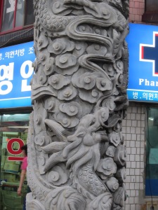A dragon carving coils around a column on the ornamental gate that leads into Incheon's Chinatown